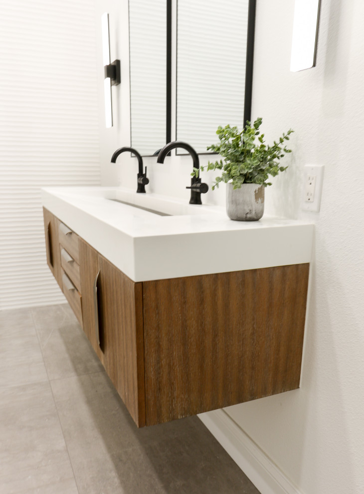 Inredning av ett modernt stort vit vitt en-suite badrum, med möbel-liknande, skåp i mellenmörkt trä, ett fristående badkar, en kantlös dusch, grå kakel, porslinskakel, vita väggar, klinkergolv i porslin, ett avlångt handfat, bänkskiva i kvarts, grått golv och med dusch som är öppen