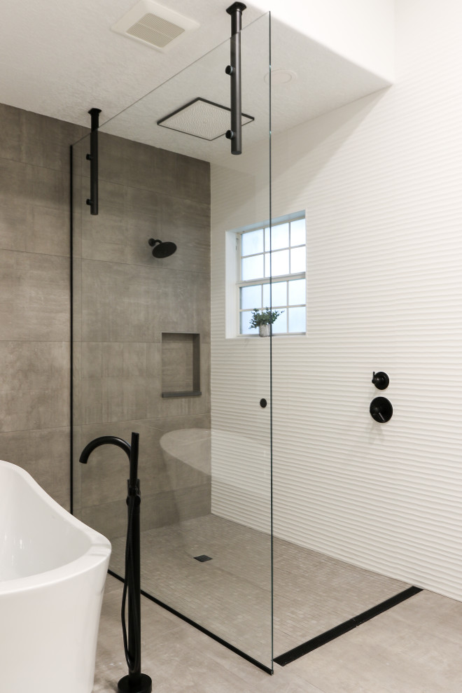 Bild på ett stort funkis vit vitt en-suite badrum, med möbel-liknande, skåp i mellenmörkt trä, ett fristående badkar, en kantlös dusch, grå kakel, porslinskakel, vita väggar, klinkergolv i porslin, ett avlångt handfat, bänkskiva i kvarts, grått golv och med dusch som är öppen