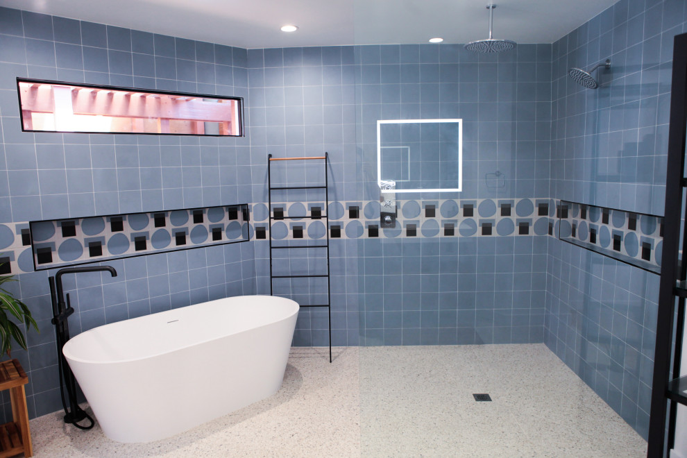 На фото: главная ванная комната среднего размера в стиле модернизм с открытыми фасадами, коричневыми фасадами, отдельно стоящей ванной, душем без бортиков, унитазом-моноблоком, синей плиткой, плиткой кабанчик, белыми стенами, полом из терраццо, подвесной раковиной, желтым полом и открытым душем с