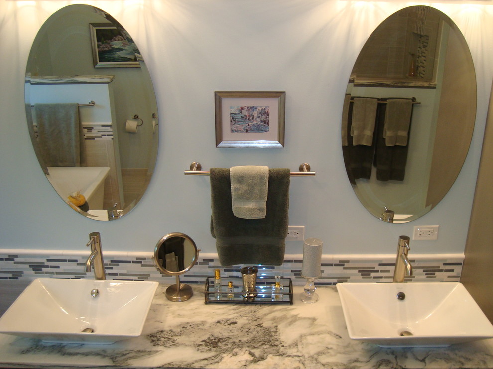 Inredning av ett maritimt stort en-suite badrum, med ett fristående handfat, skåp i shakerstil, grå skåp, marmorbänkskiva, ett fristående badkar, en öppen dusch, en toalettstol med separat cisternkåpa, grå kakel, porslinskakel, blå väggar och klinkergolv i porslin
