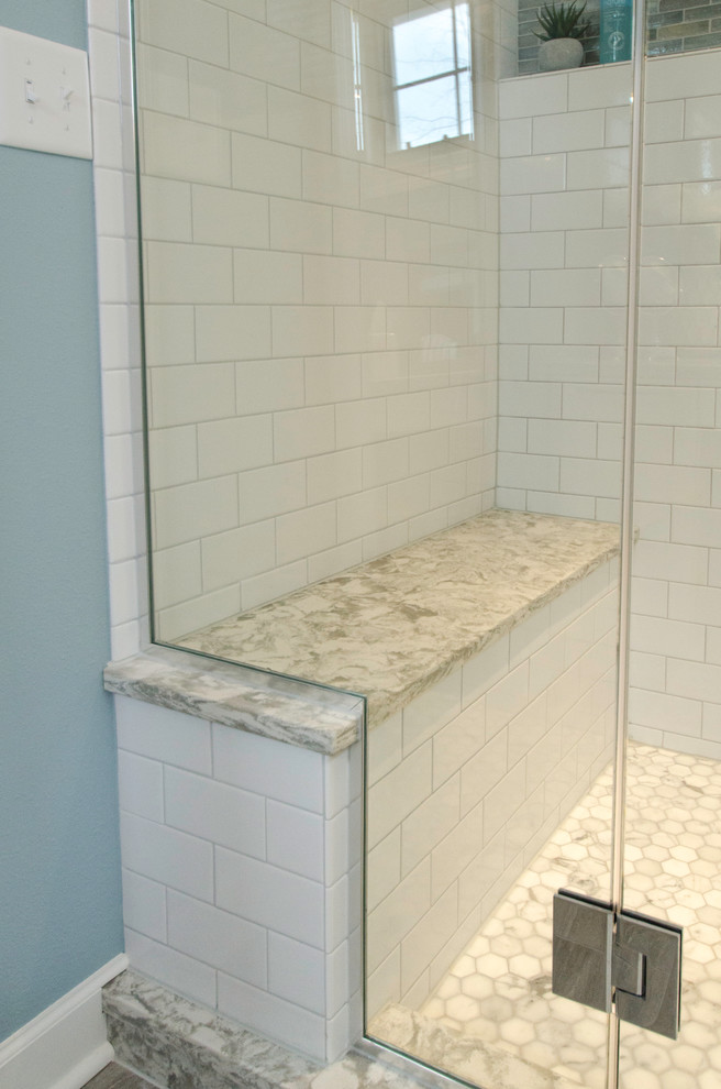 Foto på ett stort vintage en-suite badrum, med luckor med upphöjd panel, vita skåp, en hörndusch, vit kakel, blå väggar, cementgolv, ett undermonterad handfat och granitbänkskiva