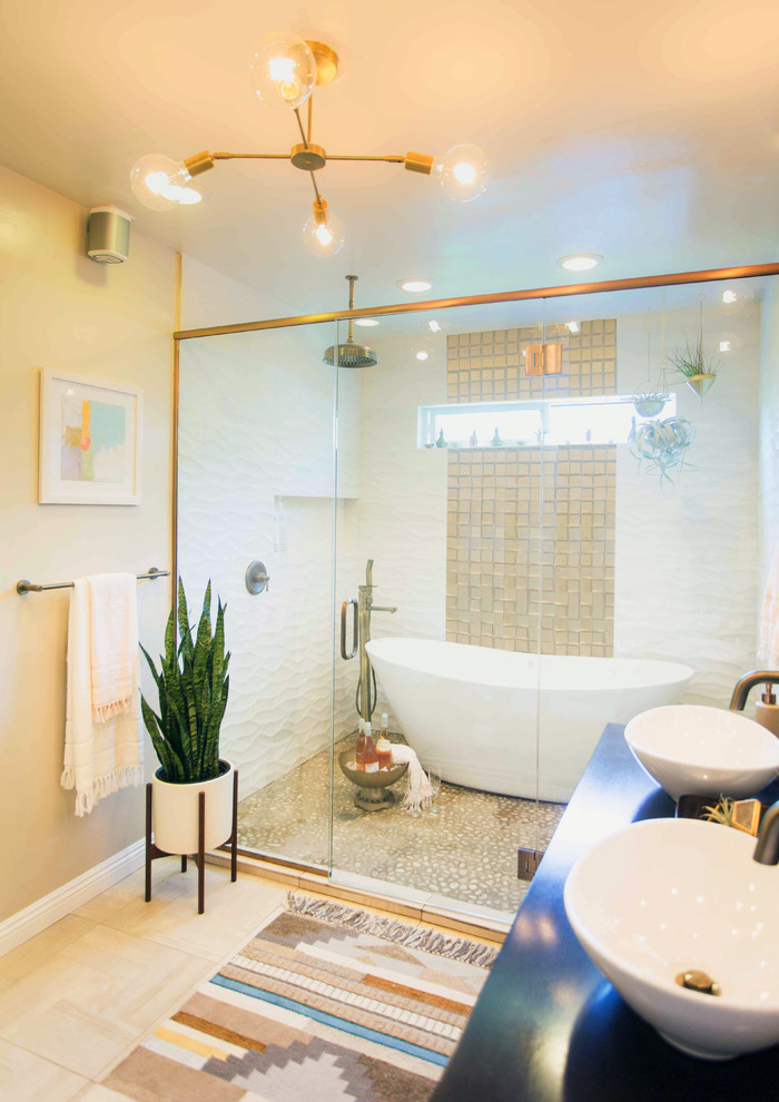 Foto på ett stort amerikanskt en-suite badrum, med möbel-liknande, svarta skåp, ett fristående badkar, våtrum, en toalettstol med hel cisternkåpa, beige väggar, ett fristående handfat, ljust trägolv, träbänkskiva och dusch med gångjärnsdörr