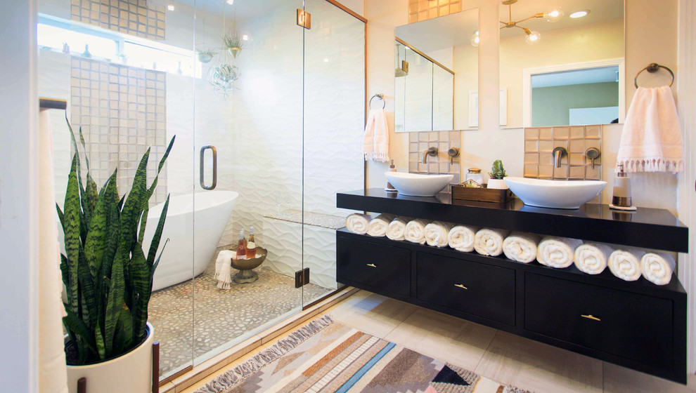 Large ensuite wet room bathroom in Denver with freestanding cabinets, black cabinets, a freestanding bath, a one-piece toilet, beige walls, a vessel sink, light hardwood flooring, wooden worktops and a hinged door.