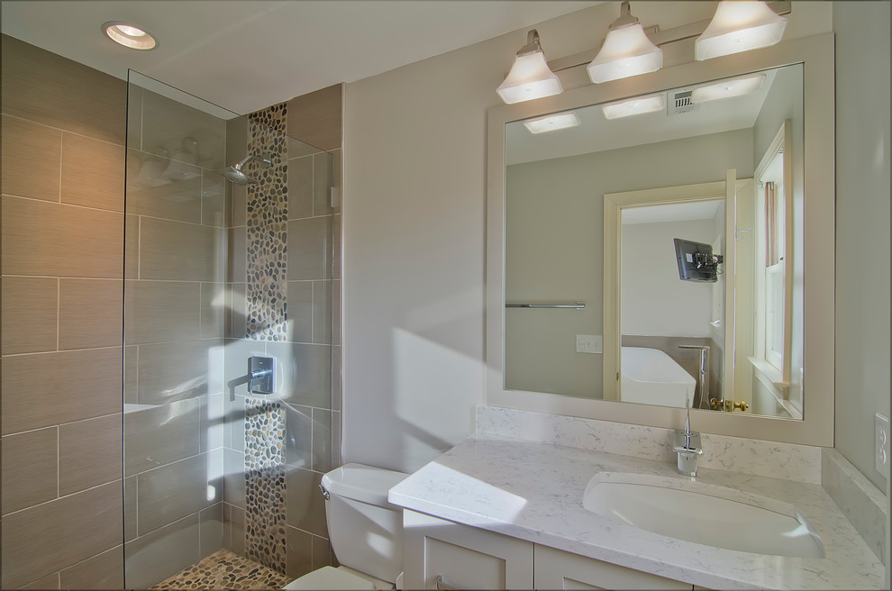 Example of a mid-sized trendy master gray tile and porcelain tile porcelain tile doorless shower design in Charlotte with an undermount sink, shaker cabinets, gray cabinets, quartz countertops, gray walls and a two-piece toilet