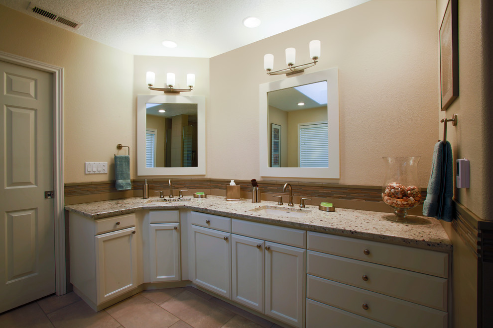Cette image montre une grande salle de bain principale minimaliste avec un lavabo encastré, un placard à porte shaker, des portes de placard blanches, un plan de toilette en granite, une baignoire indépendante, WC à poser, un carrelage beige et un mur beige.