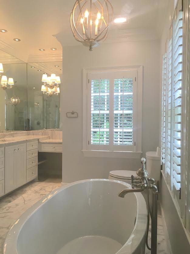 This is an example of a large traditional ensuite bathroom in Atlanta with shaker cabinets, white cabinets, a freestanding bath, a corner shower, grey tiles, white tiles, stone tiles, grey walls, marble flooring, a submerged sink, marble worktops and a hinged door.
