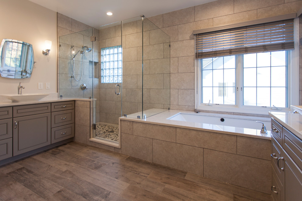 Inredning av ett klassiskt stort en-suite badrum, med luckor med upphöjd panel, grå skåp, ett undermonterat badkar, våtrum, beige kakel, porslinskakel, beige väggar, klinkergolv i keramik, ett fristående handfat, bänkskiva i kvarts, flerfärgat golv och dusch med gångjärnsdörr