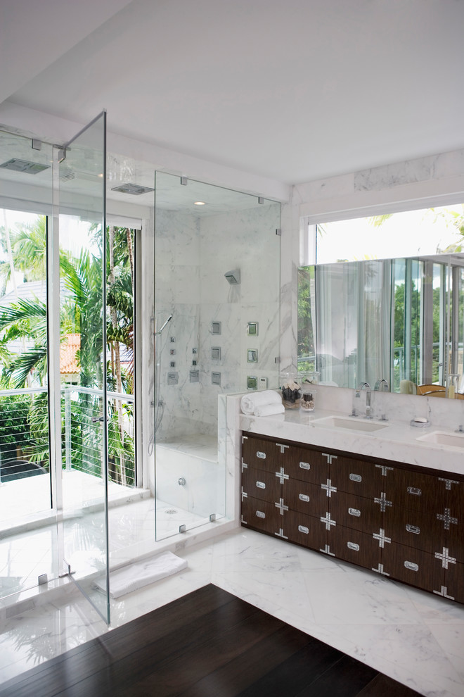 Inspiration for a large contemporary ensuite bathroom in San Francisco with flat-panel cabinets, brown cabinets, an alcove shower, white tiles, marble tiles, white walls, marble flooring, a built-in sink, marble worktops, white floors, a hinged door and a corner bath.