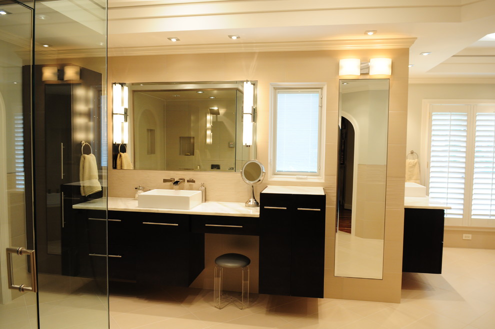 Пример оригинального дизайна: большая главная ванная комната в современном стиле с настольной раковиной, плоскими фасадами, черными фасадами, накладной ванной, угловым душем, бежевой плиткой, керамической плиткой, серыми стенами, полом из керамогранита и мраморной столешницей
