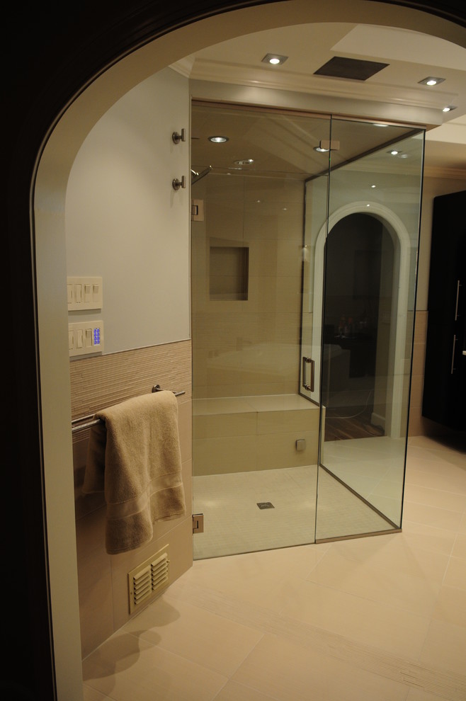 This is an example of a large contemporary ensuite bathroom in Atlanta with flat-panel cabinets, black cabinets, a built-in bath, a corner shower, beige tiles, ceramic tiles, grey walls, porcelain flooring, a vessel sink and marble worktops.