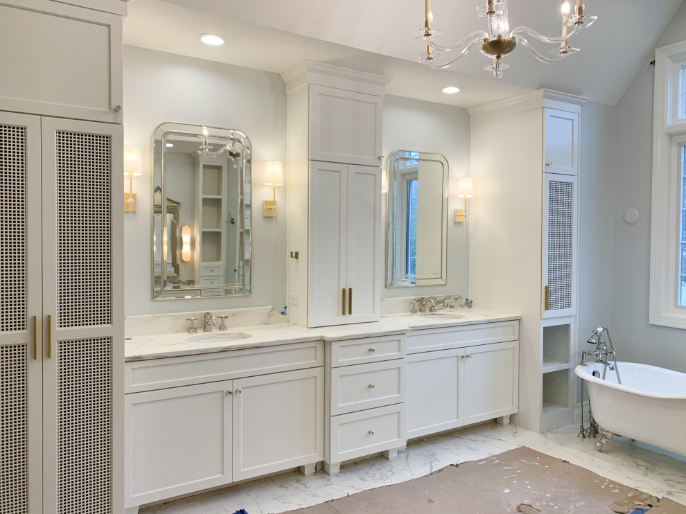 Example of a mid-sized transitional master porcelain tile, multicolored floor, double-sink, vaulted ceiling and wallpaper bathroom design in Indianapolis with shaker cabinets, white cabinets, a one-piece toilet, blue walls, an undermount sink, marble countertops, a hinged shower door, multicolored countertops and a built-in vanity