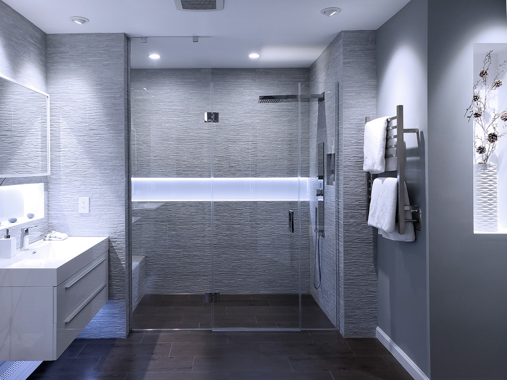 Источник вдохновения для домашнего уюта: большая главная ванная комната в современном стиле с плоскими фасадами, белыми фасадами, ванной в нише, душем без бортиков, унитазом-моноблоком, серой плиткой, керамогранитной плиткой, серыми стенами, полом из керамогранита, монолитной раковиной, коричневым полом, душем с распашными дверями и белой столешницей