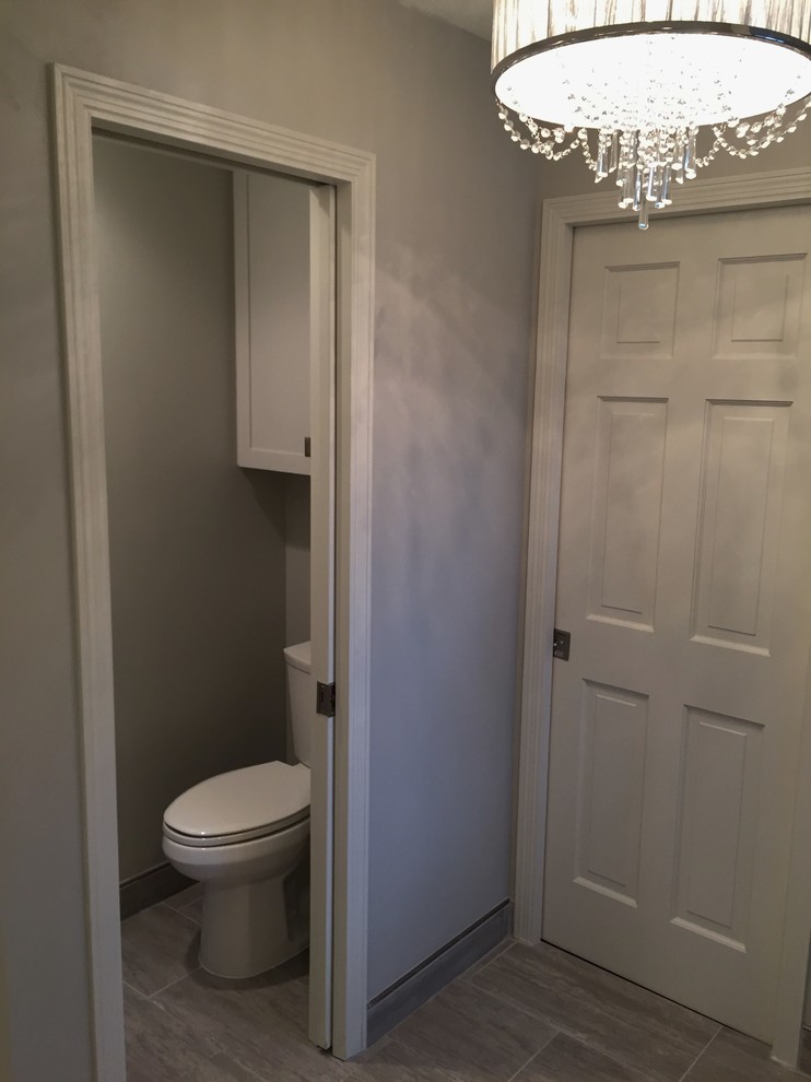 Photo of a medium sized classic ensuite bathroom in Minneapolis with shaker cabinets, grey cabinets, a freestanding bath, a walk-in shower, a one-piece toilet, white tiles, porcelain tiles, grey walls, porcelain flooring, a submerged sink, engineered stone worktops, grey floors, a hinged door and white worktops.
