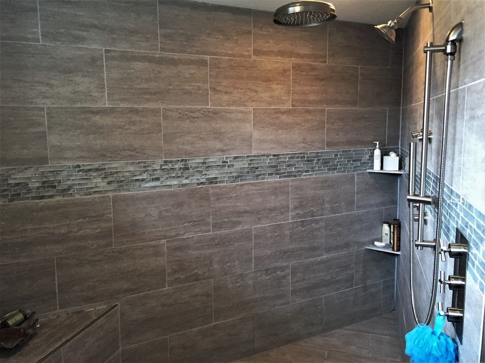 Example of a mid-sized transitional master white tile and porcelain tile porcelain tile and gray floor bathroom design in Minneapolis with shaker cabinets, gray cabinets, a one-piece toilet, gray walls, an undermount sink, quartz countertops, a hinged shower door and gray countertops