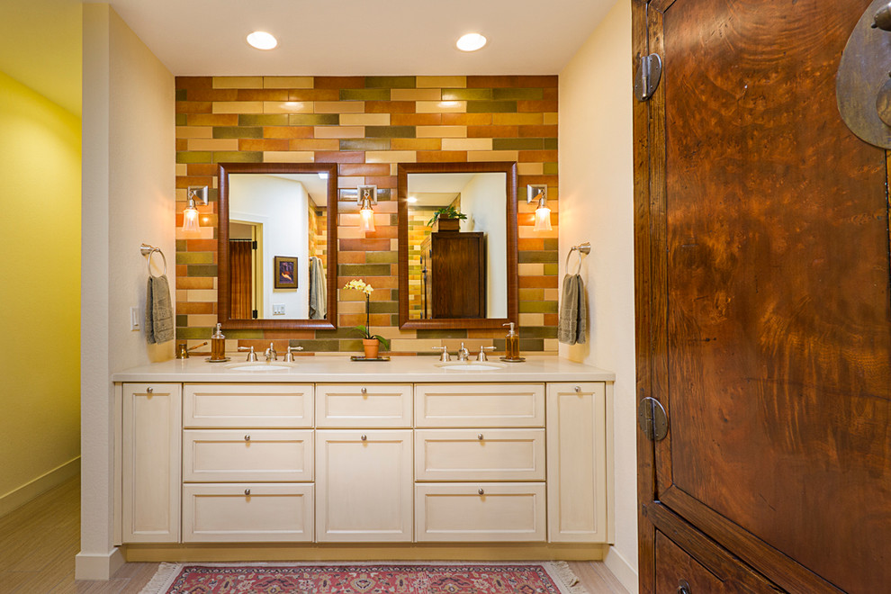 Example of a classic master multicolored tile and ceramic tile porcelain tile walk-in shower design in Phoenix with recessed-panel cabinets, yellow cabinets, yellow walls, an undermount sink and limestone countertops