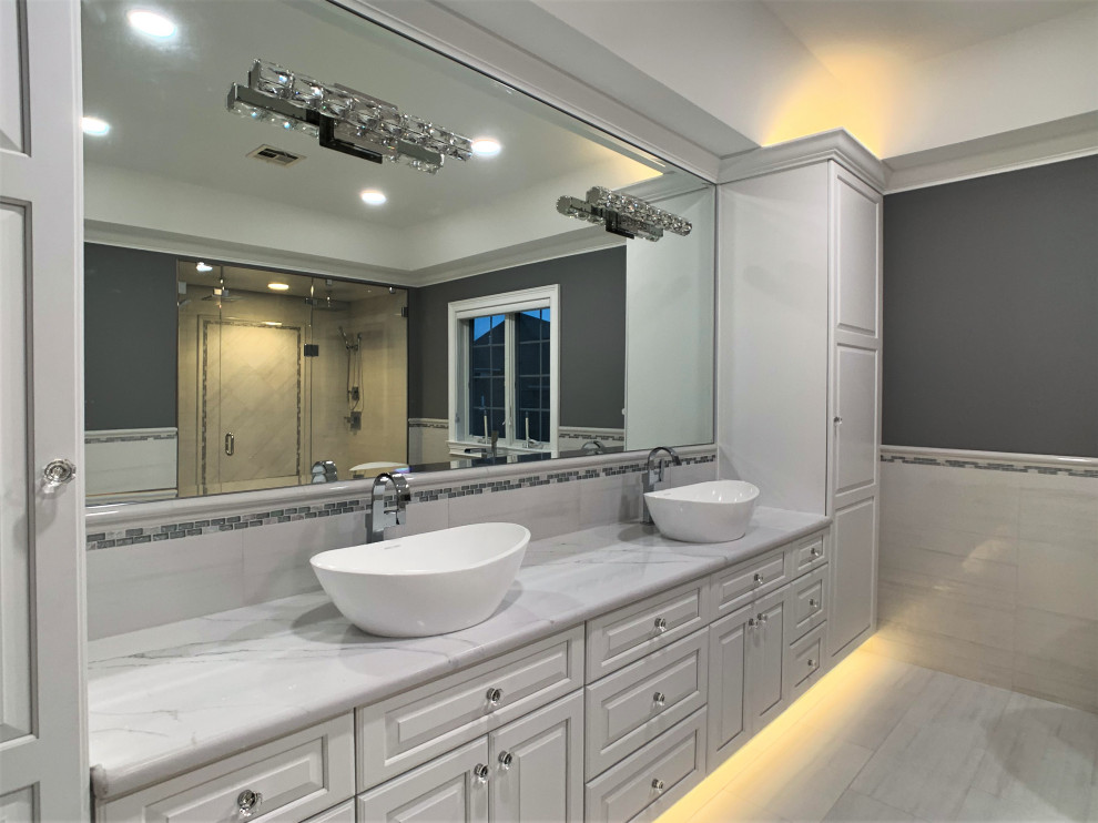 Example of a huge transitional master white tile and porcelain tile porcelain tile and white floor bathroom design in Bridgeport with raised-panel cabinets, white cabinets, a one-piece toilet, gray walls, a vessel sink, quartz countertops, a hinged shower door and white countertops