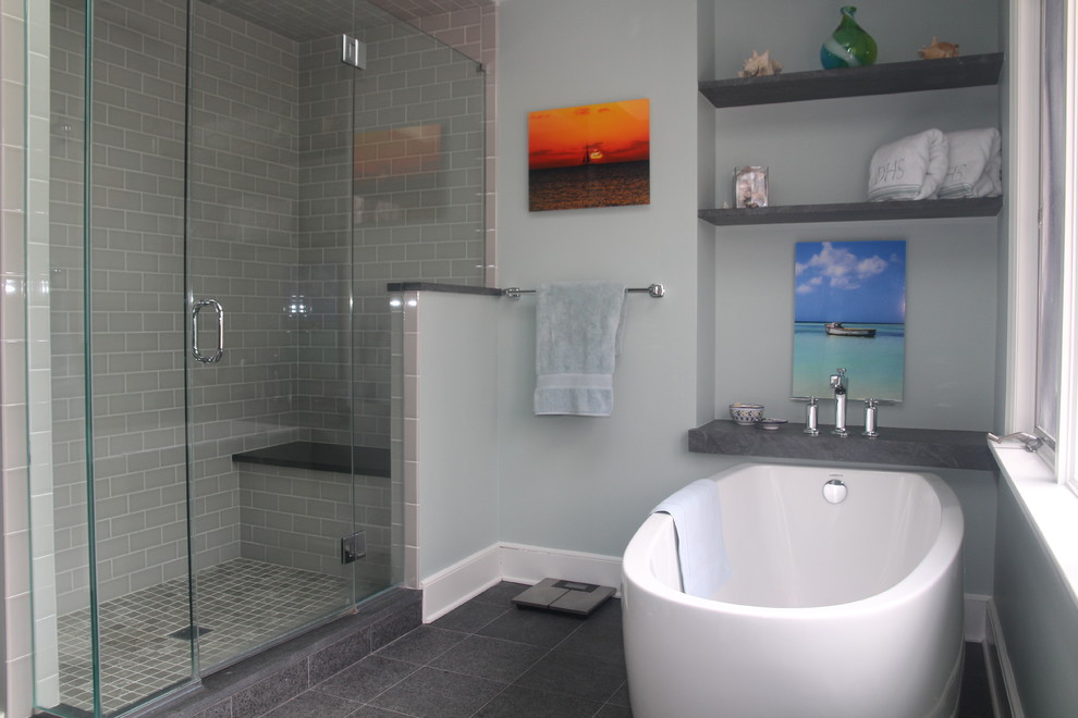 Idées déco pour une grande salle de bain principale bord de mer avec une baignoire indépendante, une douche d'angle, un carrelage gris et un mur gris.