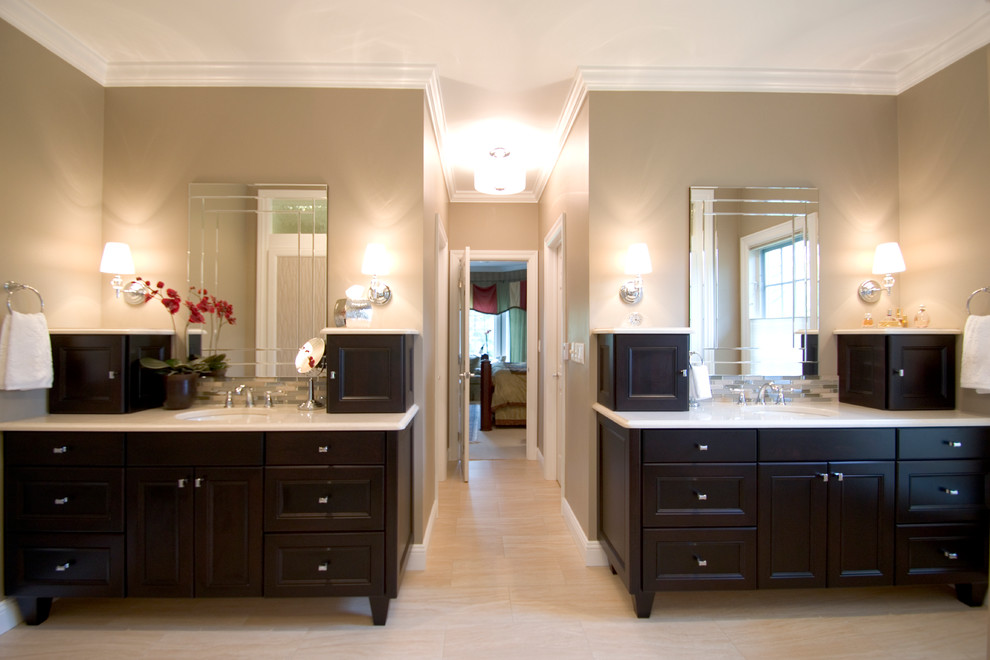 Cette image montre une salle de bain principale design avec un placard avec porte à panneau encastré, un plan de toilette en quartz modifié, un mur beige, un sol en carrelage de porcelaine, des portes de placard noires et un sol beige.