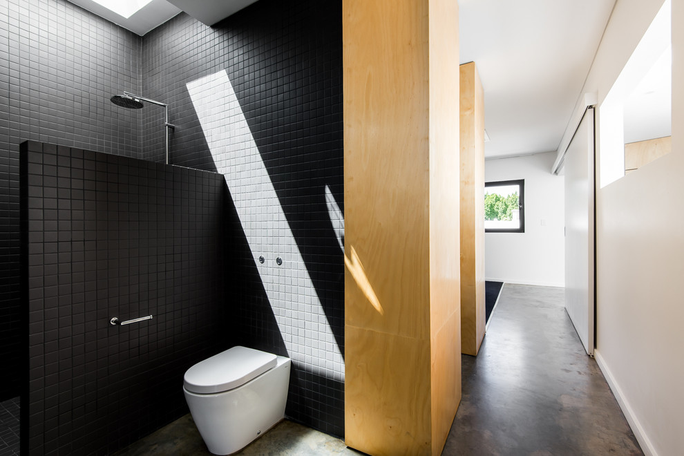Diseño de cuarto de baño principal moderno pequeño con lavabo integrado, ducha abierta, sanitario de una pieza, baldosas y/o azulejos negros, baldosas y/o azulejos de cerámica, paredes negras y suelo de cemento