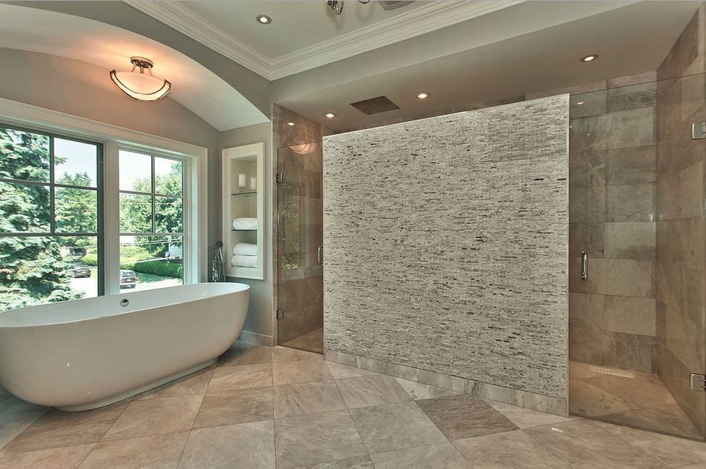 Foto på ett stort vintage en-suite badrum, med ett fristående badkar, en kantlös dusch, en toalettstol med hel cisternkåpa, grå kakel, stenkakel, grå väggar, marmorgolv, luckor med profilerade fronter, vita skåp, ett undermonterad handfat och marmorbänkskiva