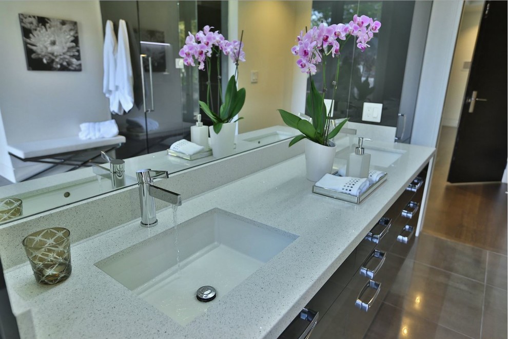 This is an example of a large contemporary ensuite bathroom in Toronto with flat-panel cabinets, grey cabinets, a built-in shower, grey tiles, white walls, porcelain flooring, a submerged sink and engineered stone worktops.