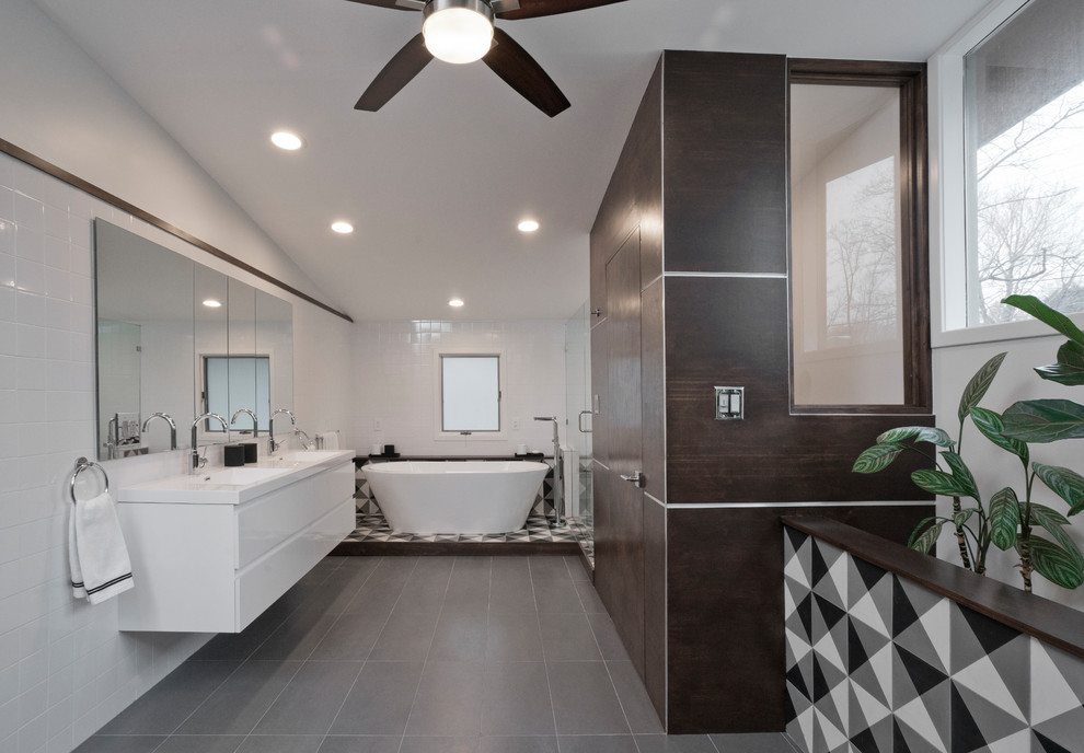 Medium sized contemporary ensuite bathroom in DC Metro with white cabinets, a freestanding bath, a built-in shower, a two-piece toilet, multi-coloured tiles, ceramic tiles, ceramic flooring, quartz worktops, grey floors, a sliding door, white worktops, flat-panel cabinets, white walls and a wall-mounted sink.