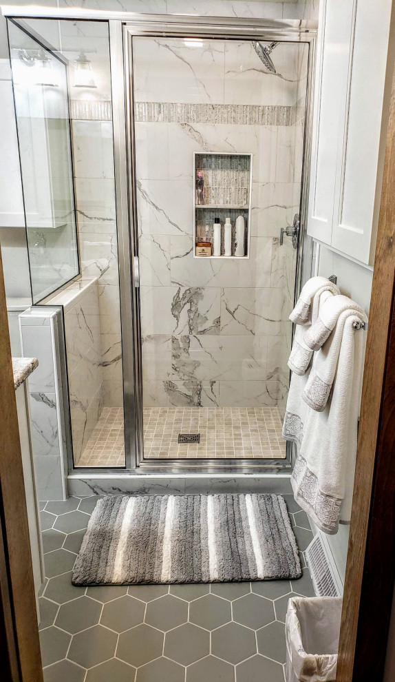 Corner shower - small traditional master white tile and porcelain tile porcelain tile and gray floor corner shower idea in New York with recessed-panel cabinets, white cabinets, a two-piece toilet, gray walls, an undermount sink, quartz countertops, a hinged shower door and brown countertops