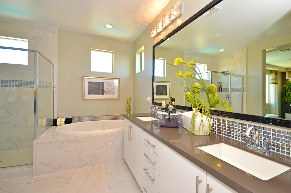 Photo of a large contemporary ensuite bathroom in Phoenix with a built-in sink, flat-panel cabinets, white cabinets, engineered stone worktops, a built-in bath, a built-in shower, a one-piece toilet, white tiles, porcelain tiles, grey walls and porcelain flooring.