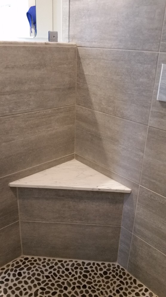 Photo of a small beach style ensuite bathroom in Boston with a corner shower, grey tiles, grey walls, dark wood cabinets, a two-piece toilet, ceramic tiles, porcelain flooring and a trough sink.