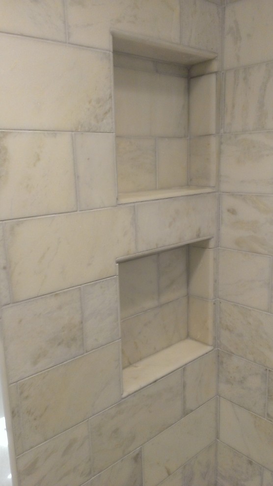 Idée de décoration pour une salle de bain design avec une douche d'angle, un carrelage gris et un carrelage métro.