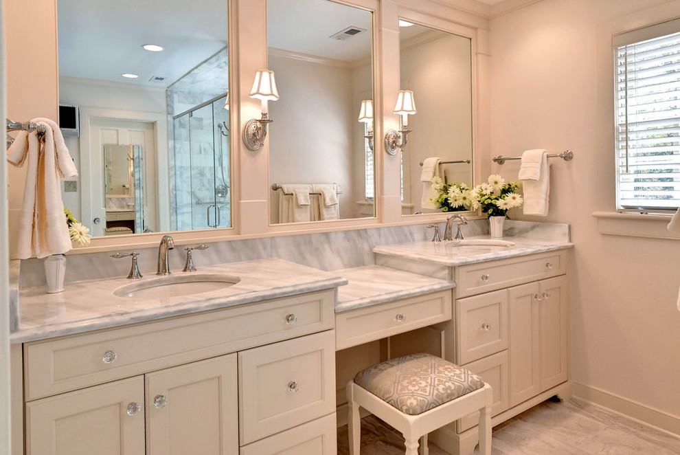 Cette photo montre une salle de bain principale chic de taille moyenne avec un sol en marbre, un plan de toilette en marbre, un carrelage beige, un mur beige, un lavabo encastré, un placard avec porte à panneau encastré et des portes de placard beiges.