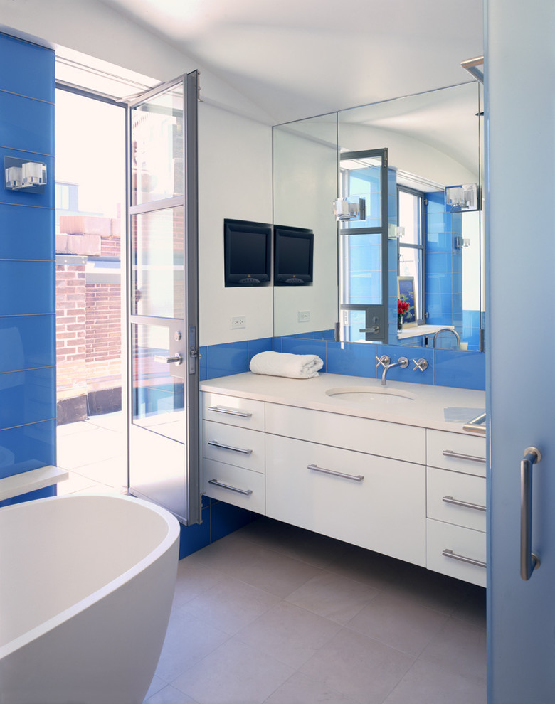 ニューヨークにあるコンテンポラリースタイルのおしゃれな浴室 (アンダーカウンター洗面器、青いタイル、ガラスタイル) の写真