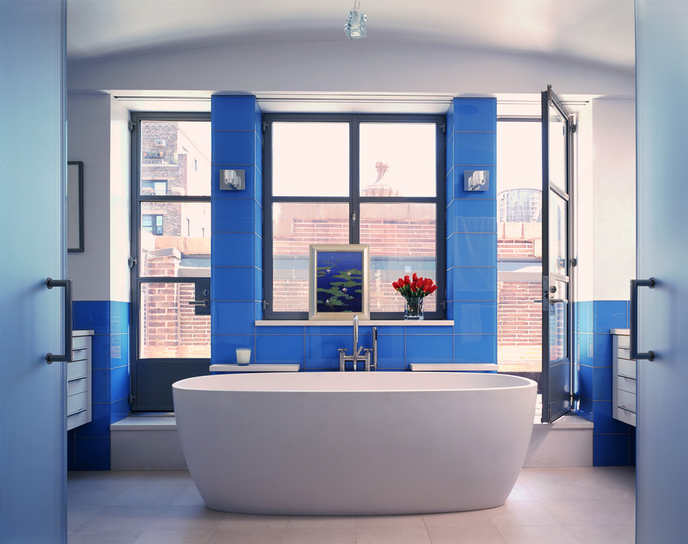 Diseño de cuarto de baño actual con baldosas y/o azulejos de vidrio y baldosas y/o azulejos azules