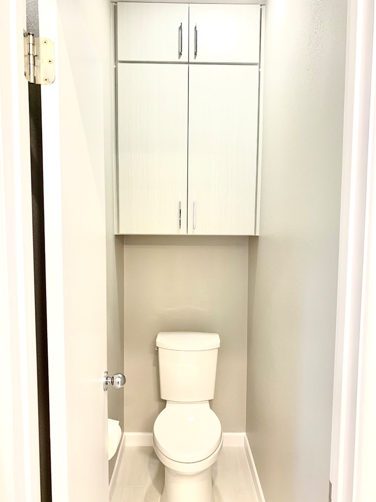 Inredning av ett modernt mellanstort flerfärgad flerfärgat toalett, med släta luckor, grå skåp, en toalettstol med separat cisternkåpa, blå kakel, glaskakel, grå väggar, klinkergolv i keramik, ett undermonterad handfat, bänkskiva i kvartsit och vitt golv
