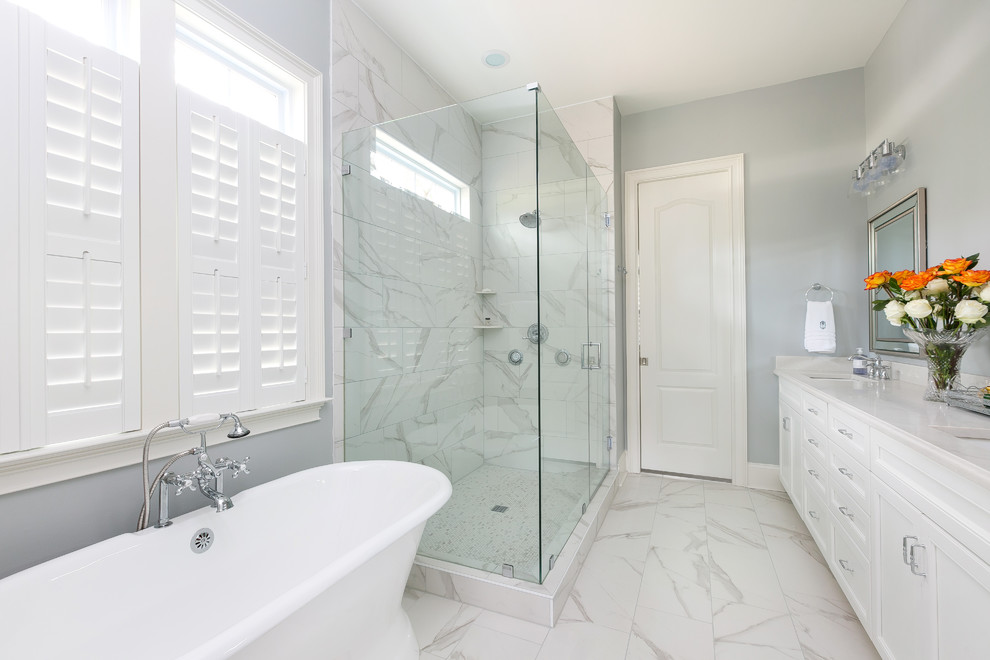 Klassisk inredning av ett stort vit vitt en-suite badrum, med skåp i shakerstil, vita skåp, ett fristående badkar, en hörndusch, grå väggar, klinkergolv i porslin, ett undermonterad handfat, bänkskiva i kvarts och vitt golv