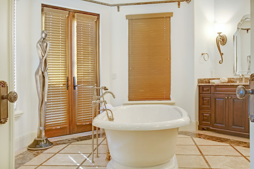Imagen de cuarto de baño mediterráneo con bañera exenta y ventanas