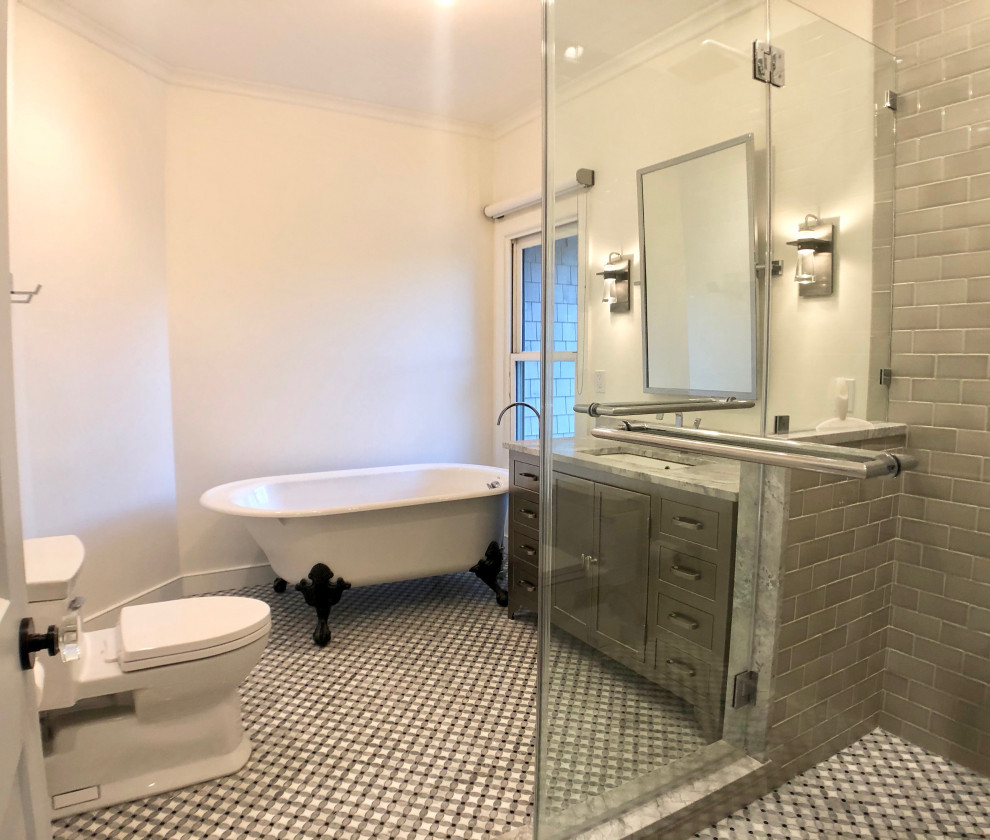 На фото: большая главная, серо-белая ванная комната в стиле неоклассика (современная классика) с фасадами островного типа, серыми фасадами, ванной на ножках, угловым душем, серой плиткой, керамической плиткой, врезной раковиной, столешницей терраццо, душем с распашными дверями, разноцветной столешницей, раздельным унитазом, белыми стенами, полом из мозаичной плитки, разноцветным полом, тумбой под одну раковину, напольной тумбой и сводчатым потолком