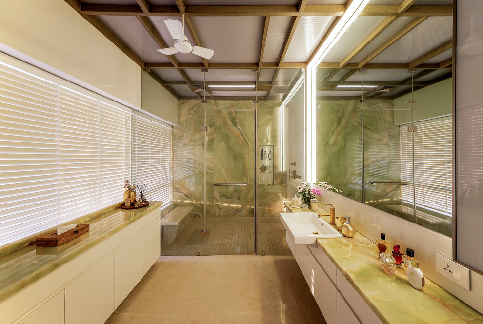 Großes Modernes Badezimmer mit flächenbündigen Schrankfronten, weißen Schränken, Duschnische, weißer Wandfarbe, Einbauwaschbecken, Onyx-Waschbecken/Waschtisch, braunem Boden und Falttür-Duschabtrennung in Pune