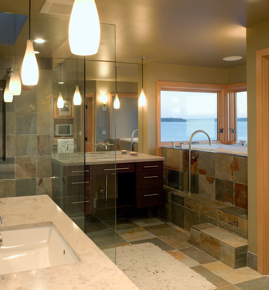 Пример оригинального дизайна: главная ванная комната в современном стиле с врезной раковиной, плоскими фасадами, темными деревянными фасадами, столешницей из известняка, накладной ванной, угловым душем, унитазом-моноблоком, каменной плиткой, полом из сланца и зелеными стенами