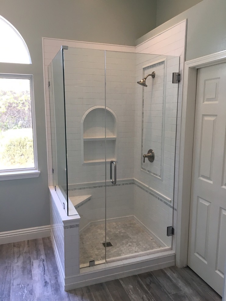Medium sized farmhouse ensuite bathroom in Los Angeles with shaker cabinets, white cabinets, a corner shower, white tiles, metro tiles, blue walls, porcelain flooring, a submerged sink and marble worktops.