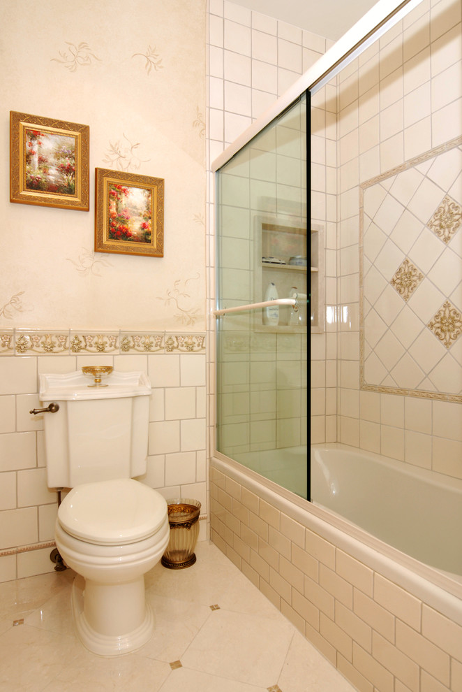 ニューヨークにあるラグジュアリーな広いトラディショナルスタイルのおしゃれなマスターバスルーム (オーバーカウンターシンク、ベージュのタイル、白い壁、セラミックタイルの床、アルコーブ型浴槽、シャワー付き浴槽	、一体型トイレ	) の写真