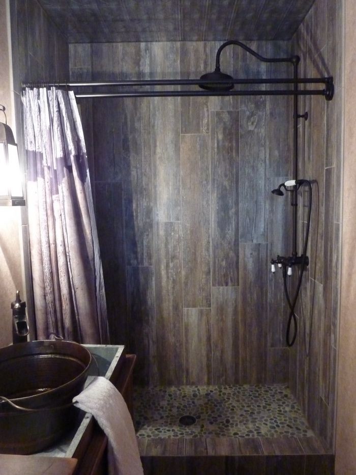 Foto på ett mellanstort rustikt badrum med dusch, med luckor med lamellpanel, skåp i mörkt trä, en dusch i en alkov, beige kakel, svart kakel, brun kakel, grå kakel, porslinskakel, ett fristående handfat och träbänkskiva