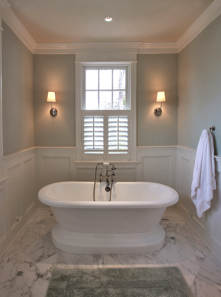 Exemple d'une grande salle de bain principale chic avec une baignoire indépendante, un carrelage blanc, un carrelage de pierre, un mur vert et un sol en marbre.