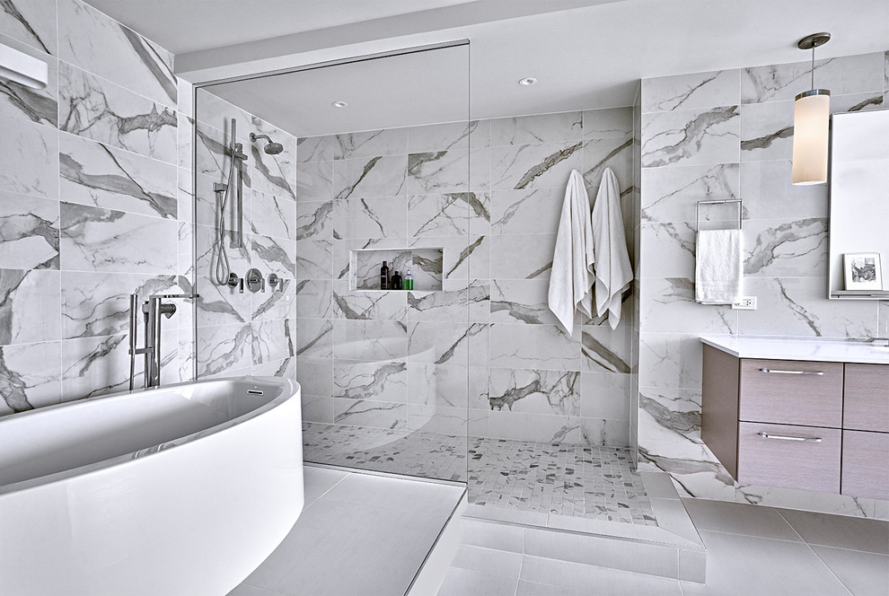 This is an example of an expansive modern ensuite bathroom in Chicago with flat-panel cabinets, grey cabinets, a freestanding bath, a walk-in shower, a one-piece toilet, white tiles, porcelain tiles, white walls, porcelain flooring, a submerged sink, engineered stone worktops, white floors, an open shower and white worktops.