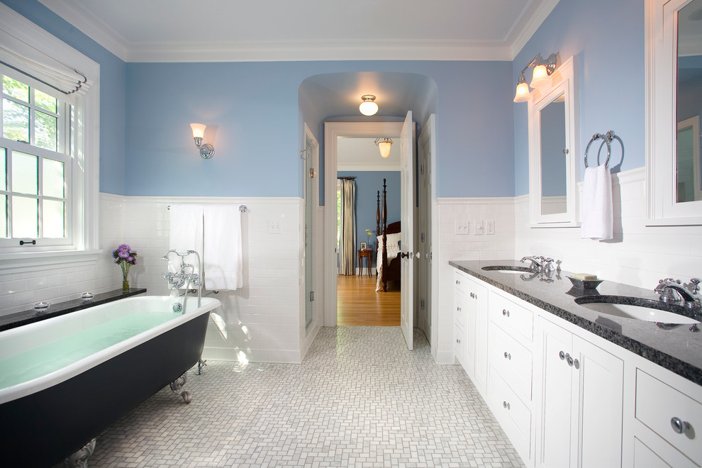 Пример оригинального дизайна: ванная комната: освещение в классическом стиле с врезной раковиной, фасадами с утопленной филенкой, белыми фасадами, ванной на ножках, белой плиткой и плиткой кабанчик