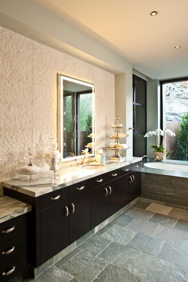 Идея дизайна: большая главная ванная комната в современном стиле с врезной раковиной, плоскими фасадами, мраморной столешницей, полновстраиваемой ванной, серой плиткой, каменной плиткой, полом из сланца, темными деревянными фасадами, серыми стенами и серым полом