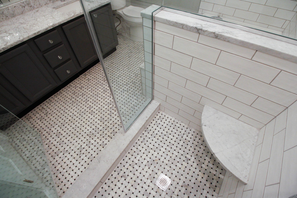 Стильный дизайн: главная ванная комната среднего размера в классическом стиле с плоскими фасадами, серыми фасадами, накладной ванной, угловым душем, писсуаром, белой плиткой, керамической плиткой, серыми стенами, полом из мозаичной плитки, врезной раковиной, мраморной столешницей, белым полом и душем с распашными дверями - последний тренд