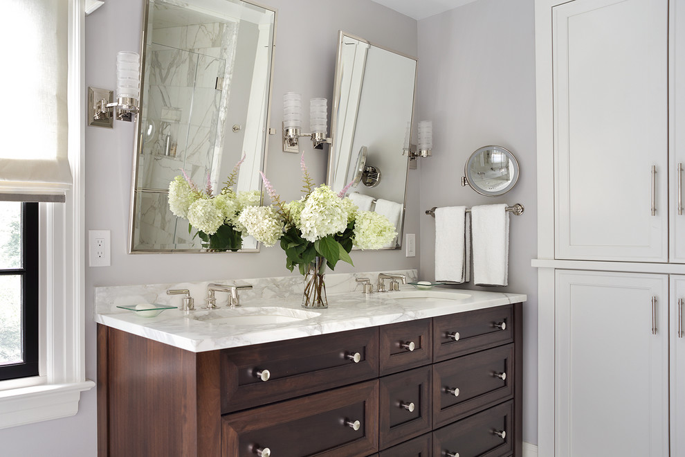 Klassisk inredning av ett stort vit vitt en-suite badrum, med grå väggar, ett undermonterad handfat, marmorbänkskiva, luckor med infälld panel och skåp i mörkt trä