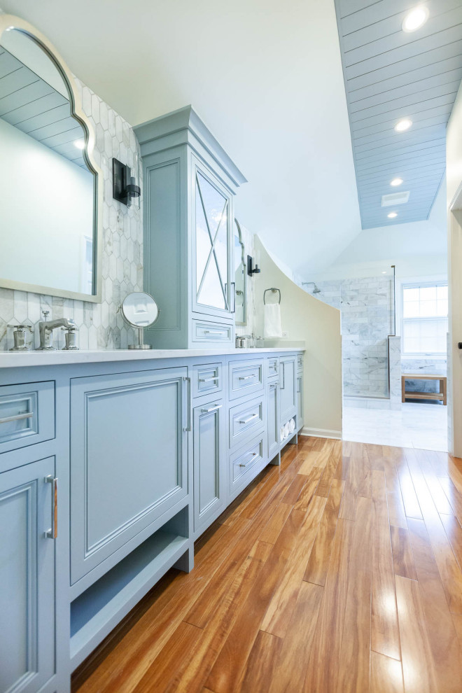 Cette image montre une grande salle de bain principale traditionnelle avec un placard à porte affleurante, des portes de placard bleues, une baignoire posée, une douche d'angle, WC séparés, un carrelage gris, du carrelage en marbre, un mur blanc, un sol en marbre, un lavabo encastré, un plan de toilette en quartz modifié, un sol gris, une cabine de douche à porte battante, un plan de toilette gris, une niche, meuble double vasque, meuble-lavabo sur pied, un plafond en lambris de bois et boiseries.