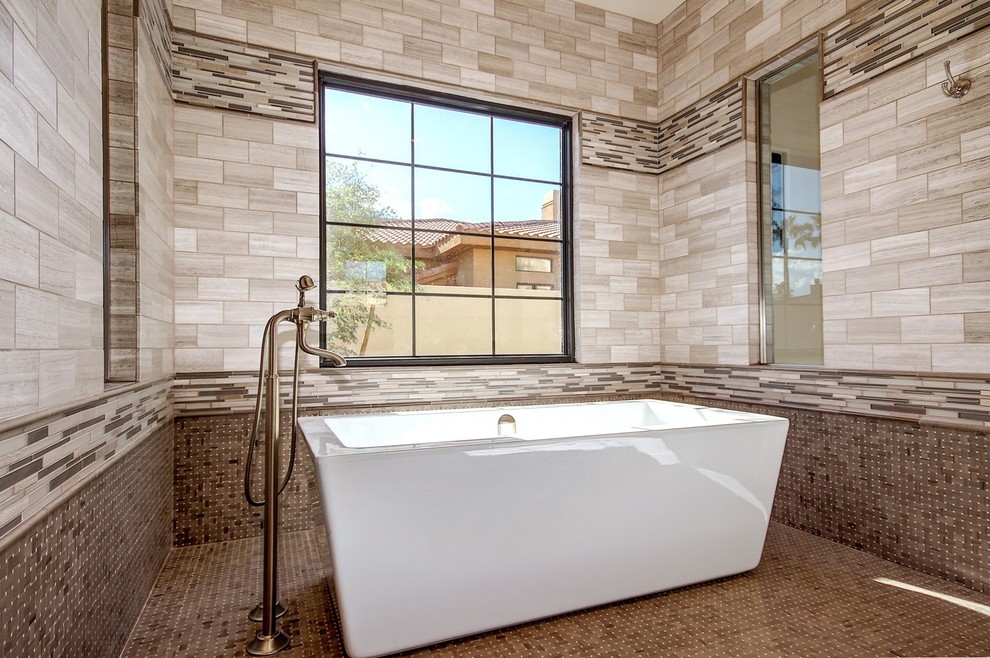 Cette image montre une grande salle de bain principale méditerranéenne avec un placard avec porte à panneau surélevé, des portes de placard blanches, une baignoire indépendante, une douche ouverte, WC séparés, un carrelage gris, un carrelage de pierre, un sol en marbre, un lavabo posé, un plan de toilette en quartz, une cabine de douche à porte battante, un mur beige et un sol marron.